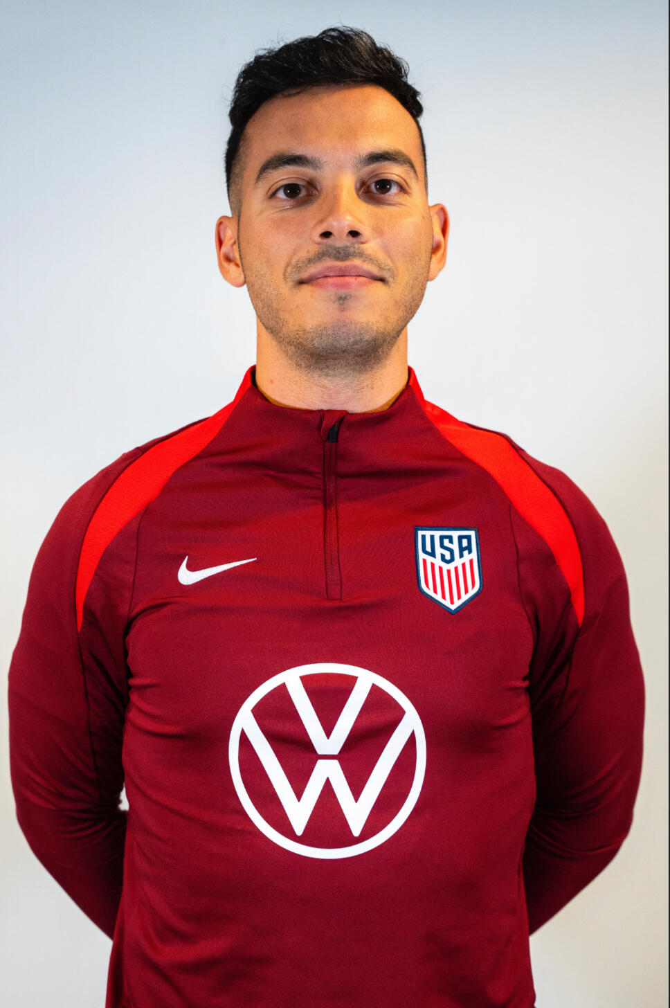 A photo of a man wearing a red jacket from the waist up. 