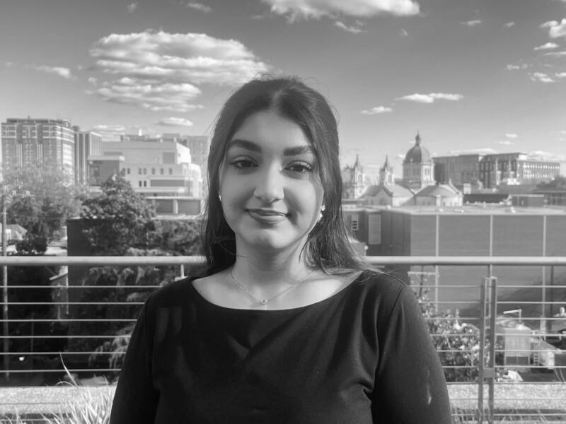 A photo of a woman standing in front of a city skyline. 