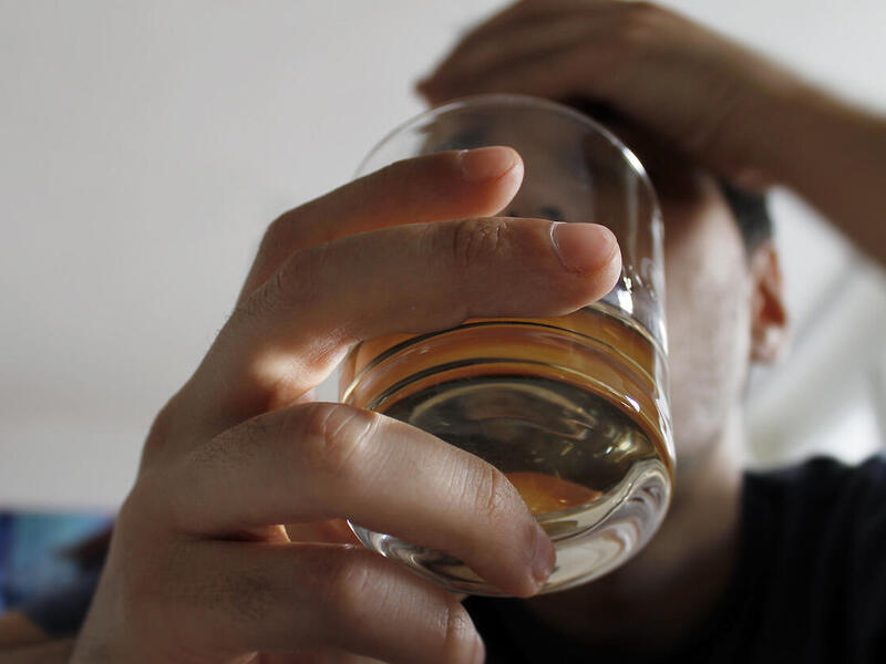 Photo of a person holding a short glass.