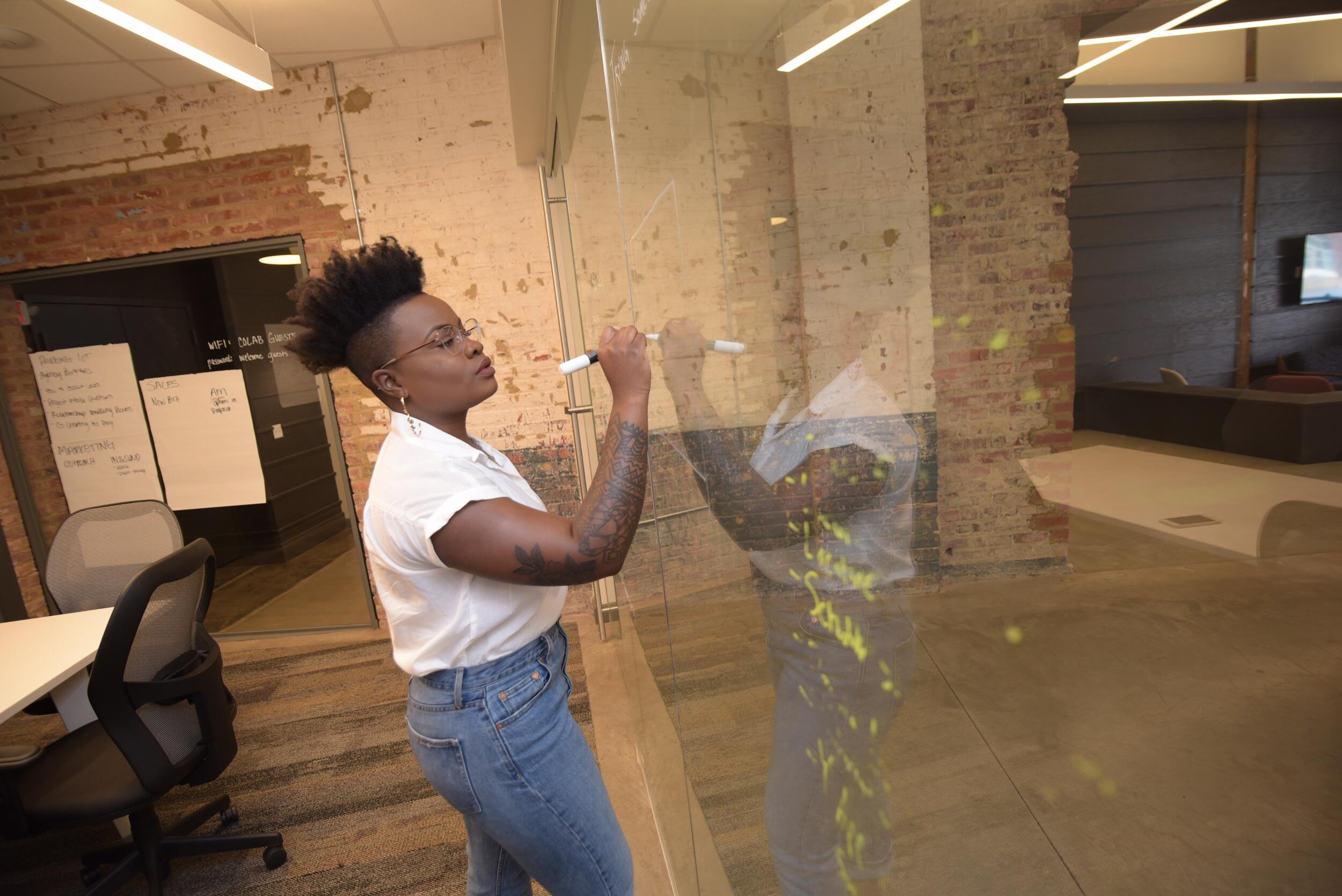 Woman drawing on glass board. 