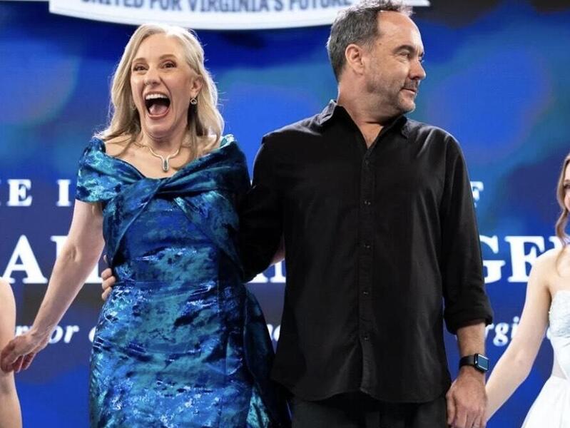 A photo of a woman standing to the left of a man on a stage. 