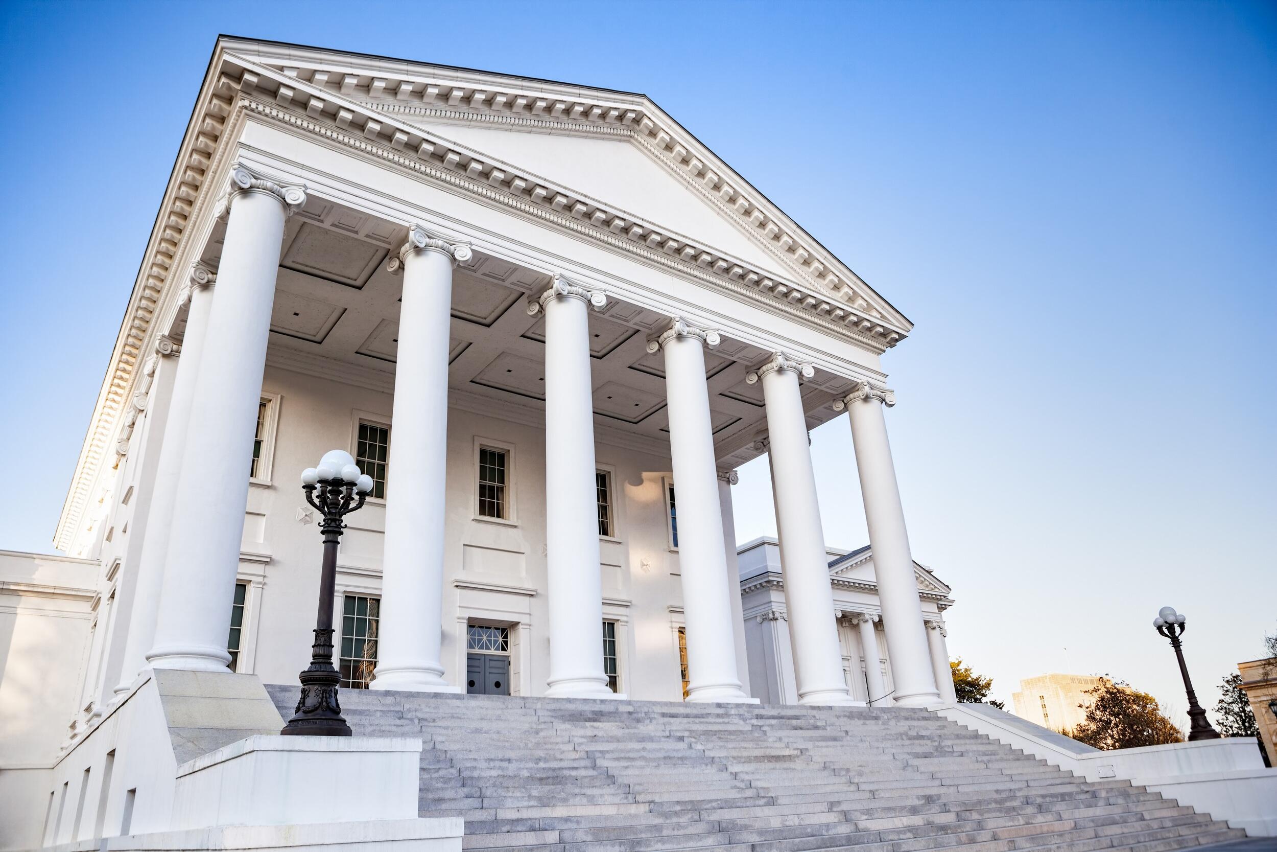 The Virginia state capitol building facing its southern facade with tall columns and a wide staircase.