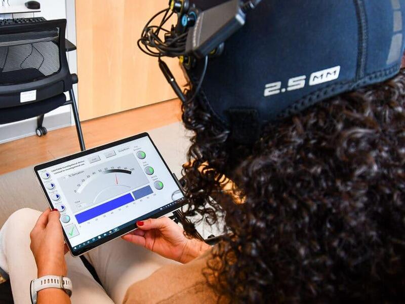 A photo of a woman looking at a tablet. 