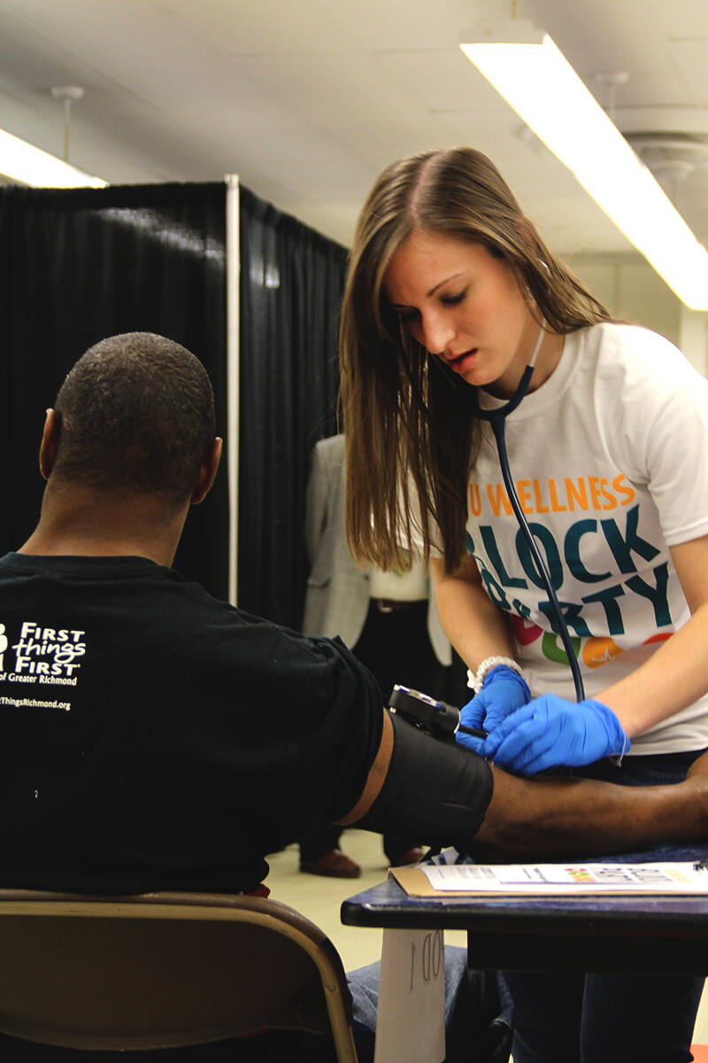 A volunteer health sciences student checks the blood pressure of a participant during the MCV Campus Student Government Association's eighth annual VCU Wellness Block Party. 
