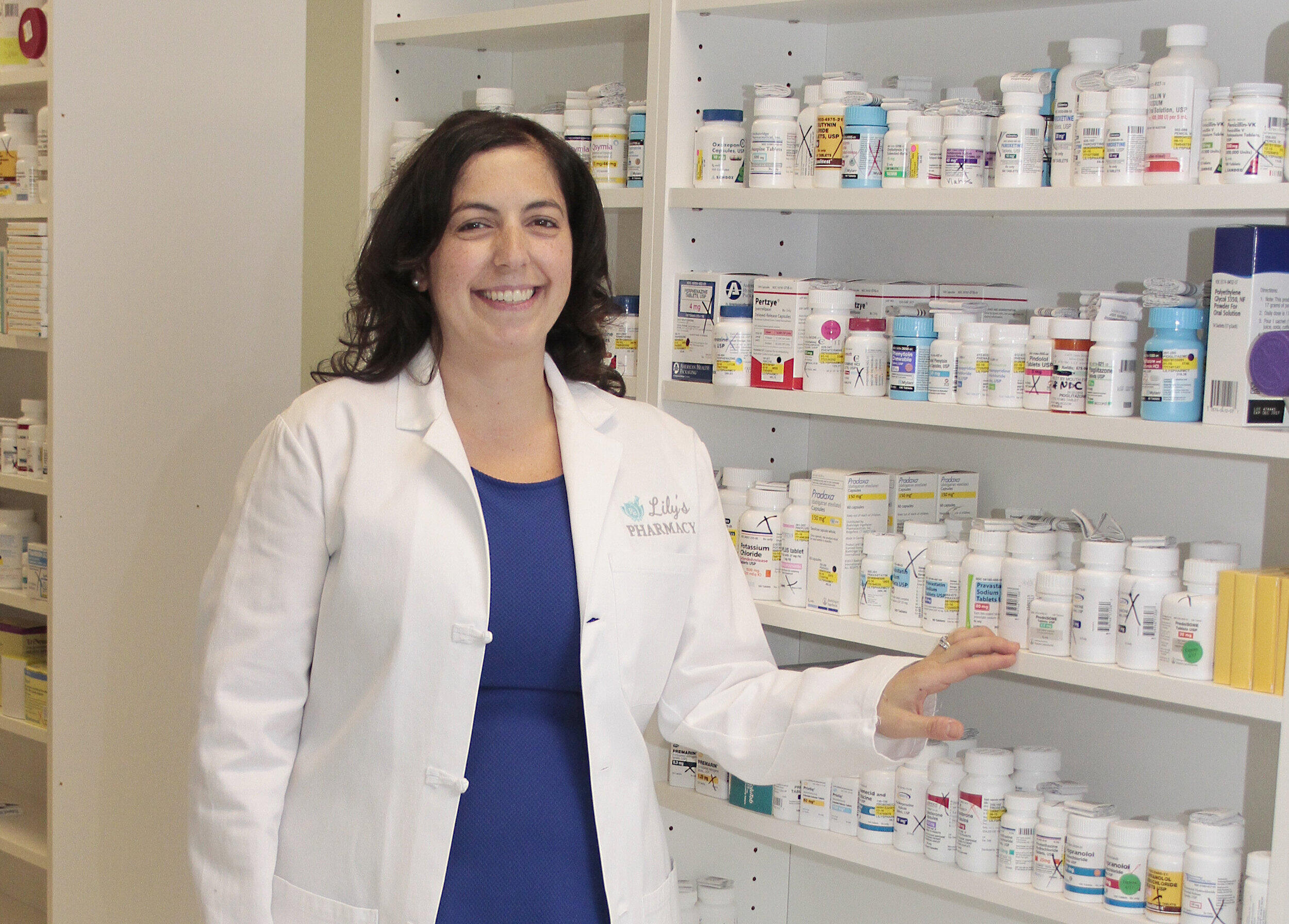 Jennifer Shannon standing in front of a cabinet of pharmaceutical products. 