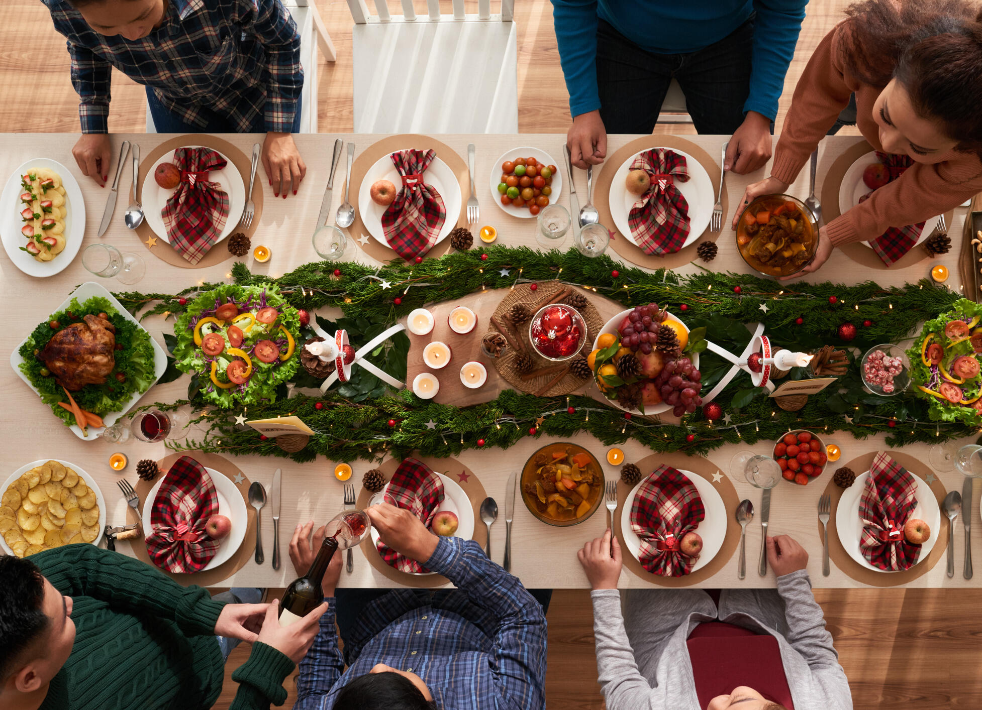 An overhead shot of a family dinner table, decorated for the holidays.