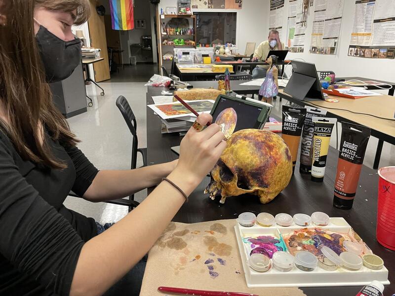 Emily Pitts, a sophomore anthropology major, paints a 3-D-printed replica of the JB55 Connecticut "vampire" skull. (Brian McNeill, Enterprise Marketing and Communications)