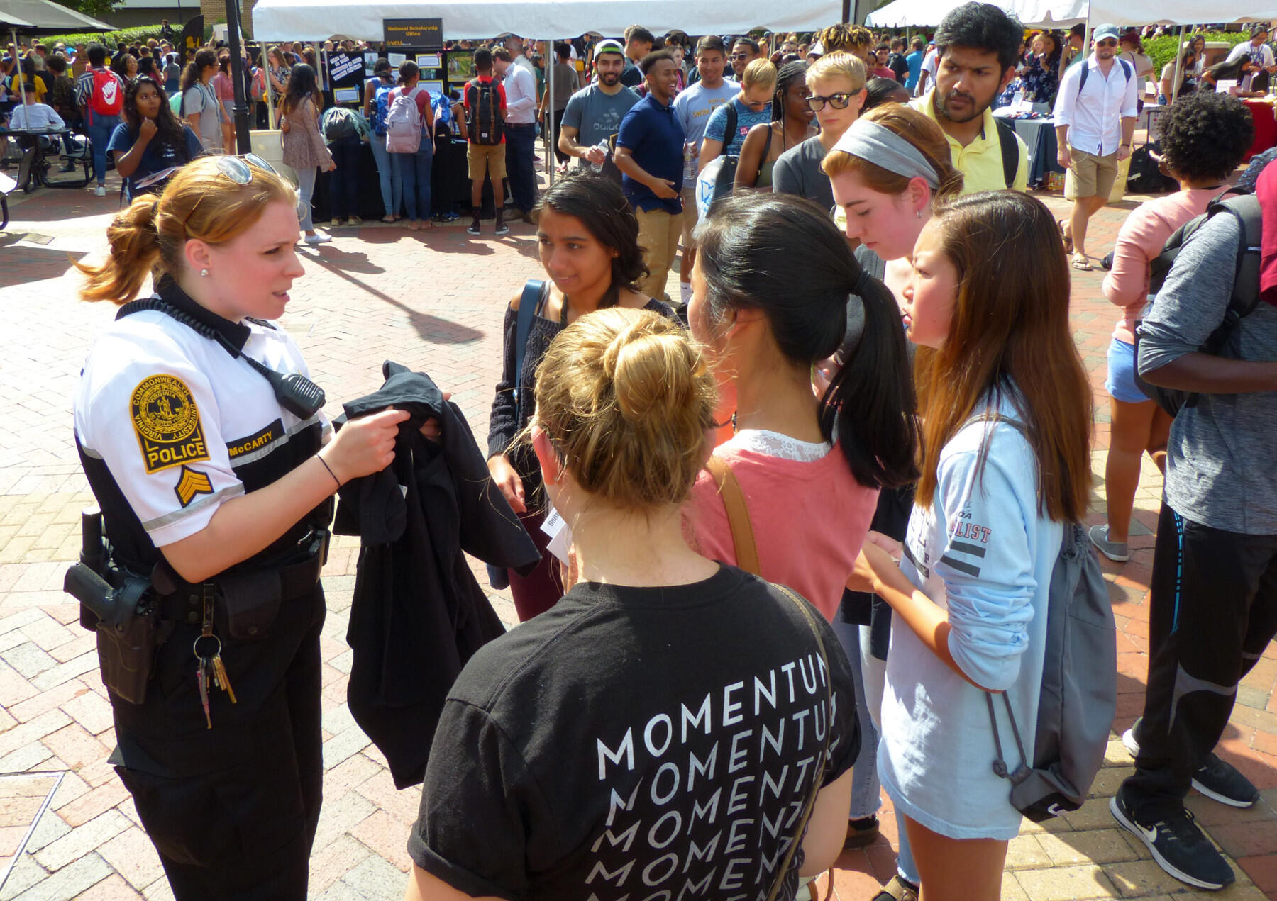 A police officer, at left, speaks to students.