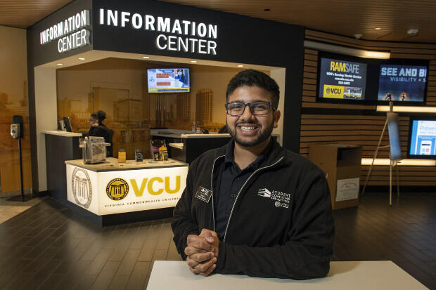Smiling man in black coat with Student Commons and Activities VCU imprinted on it.