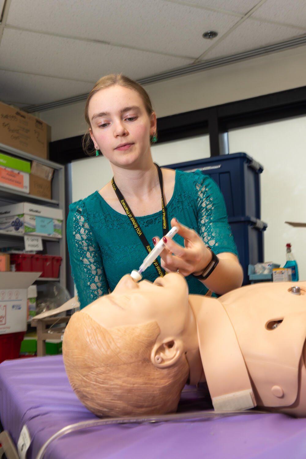 Victoria Allen, a pharmacy student, practices administering naloxone via nasal spray. (Photo by Kevin Morley, University Relations)