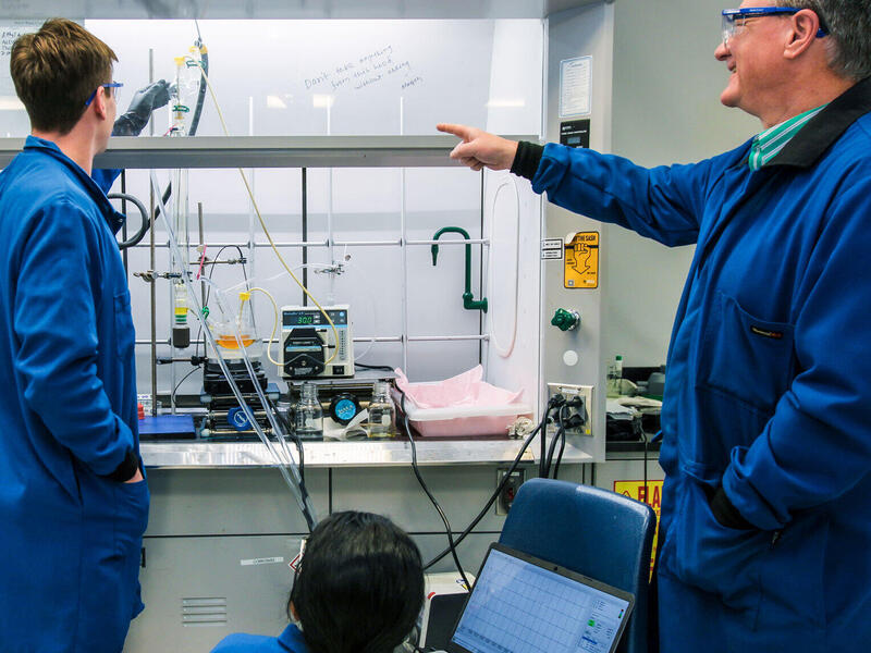 A photo of three people in a lab.