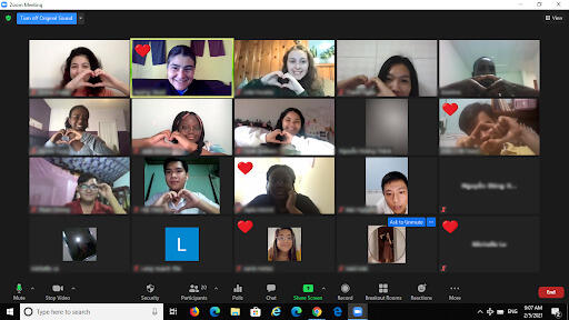 Zoom screengrab where students are making a heart shape with their hands.