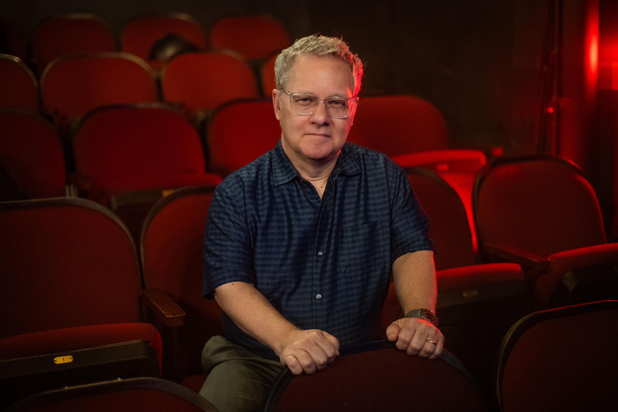 A photo of a man sitting in an empty theater. 