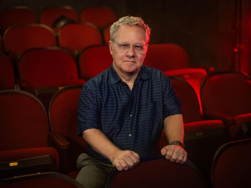 A photo of a man sitting in an empty theater. 
