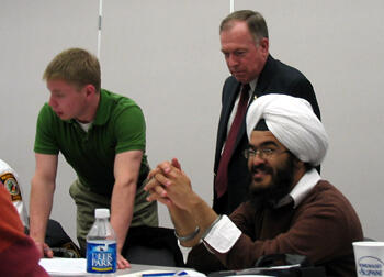 VCU Homeland Security and Emergency Preparedness seniors Brian Hickey (left) and Gurvinderpal "GP" Chaudhry (right) participate in a daylong  tabletop exercise designed to test their skills as professor William Parrish (center) checks their progress.  The tabletop exercise was a scenario-driven exercise to test the students’ ability to coordinate a response in the areas of emergency management, intelligence fusion, firefighting, external affairs, public safety and public health and medical resources.  VCU was the first major research university in the country to develop a homeland security and emergency preparedness undergraduate degree and will offer a master’s program beginning next fall. Photo by Mike Porter, VCU Office of University News Services. 