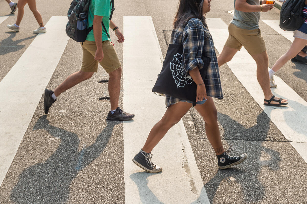 People walking across a cross walk 