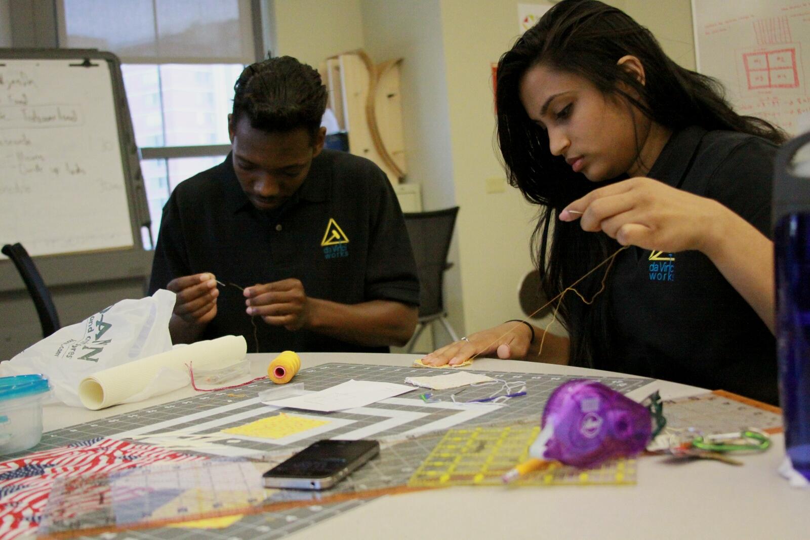 Desmund Delaney and Poojah Shah work on assembling a quilt, using a kit they're developing that will allow customers to make a quilt without the need for a sewing machine or any prior sewing experience. 