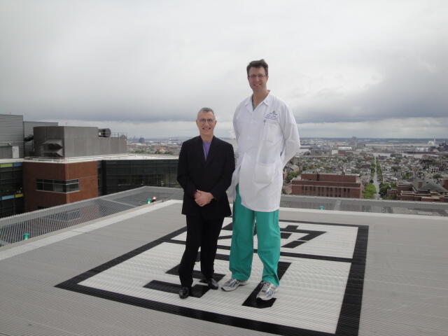 Two men stand in the middle of a helipad.