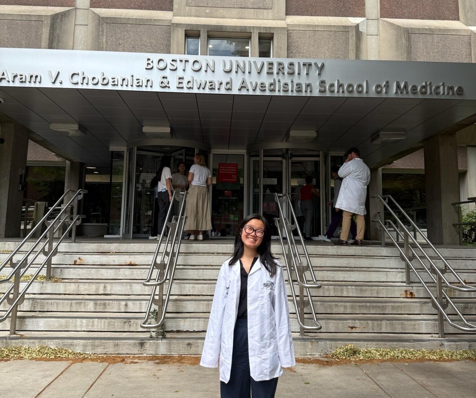 A photo of a woman standing in front of a building. 