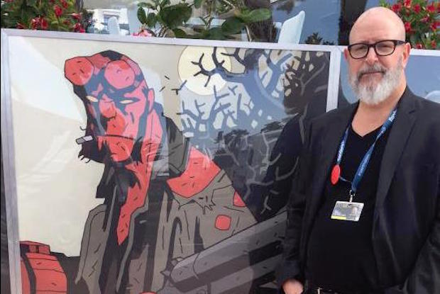 Hellboy creator Mike Mignola standing next to a picture of Hellboy comic character