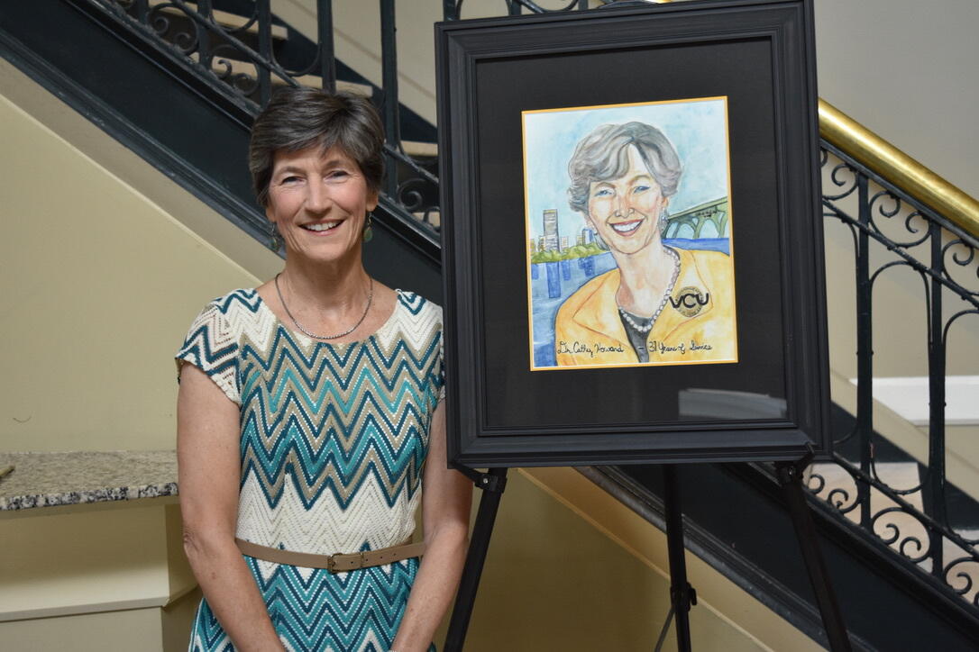 Cathy Howard poses next to a painting of her likeness.