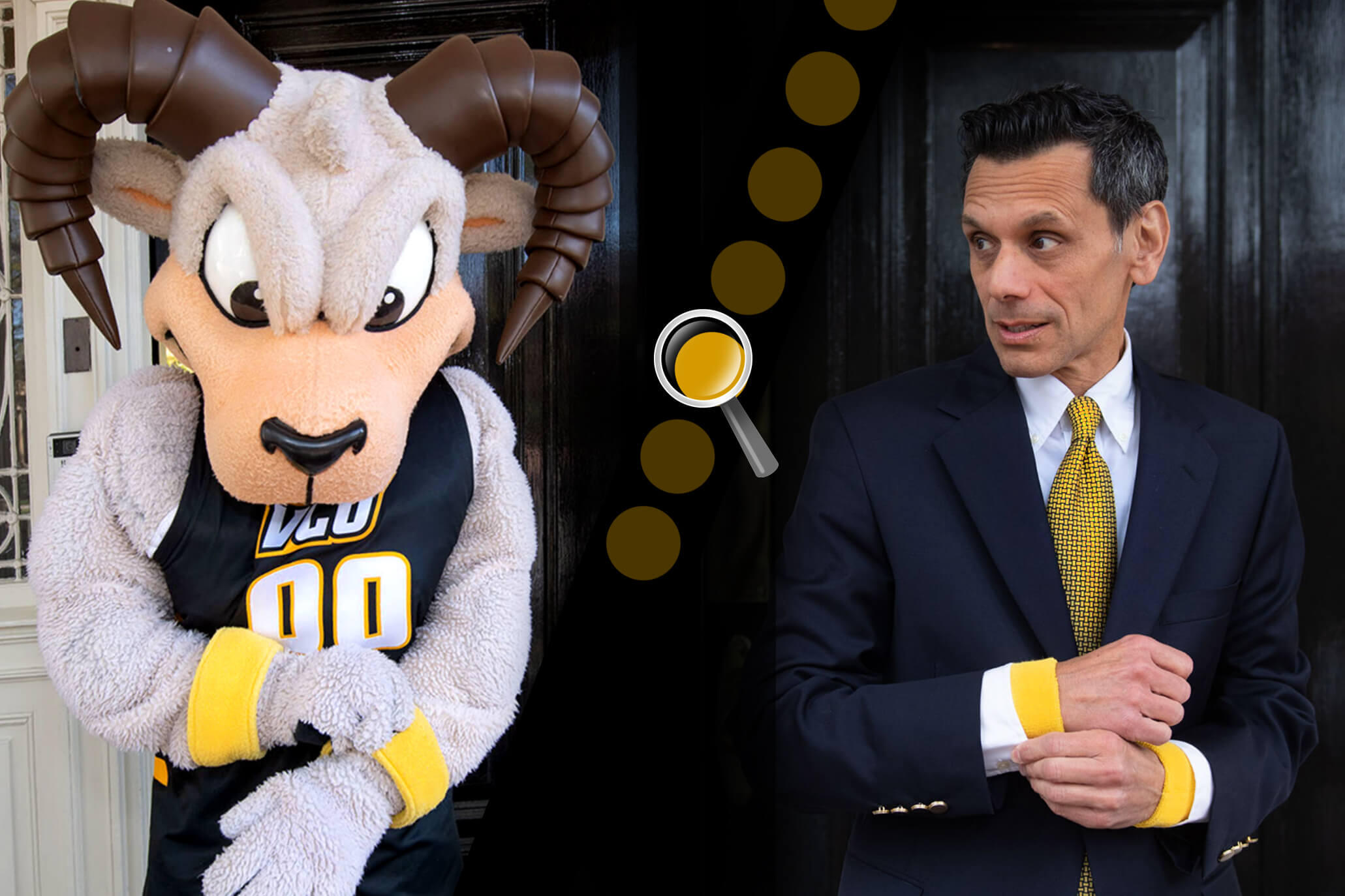 A man in a suit and tie standing to the right of a ram mascot costume. 