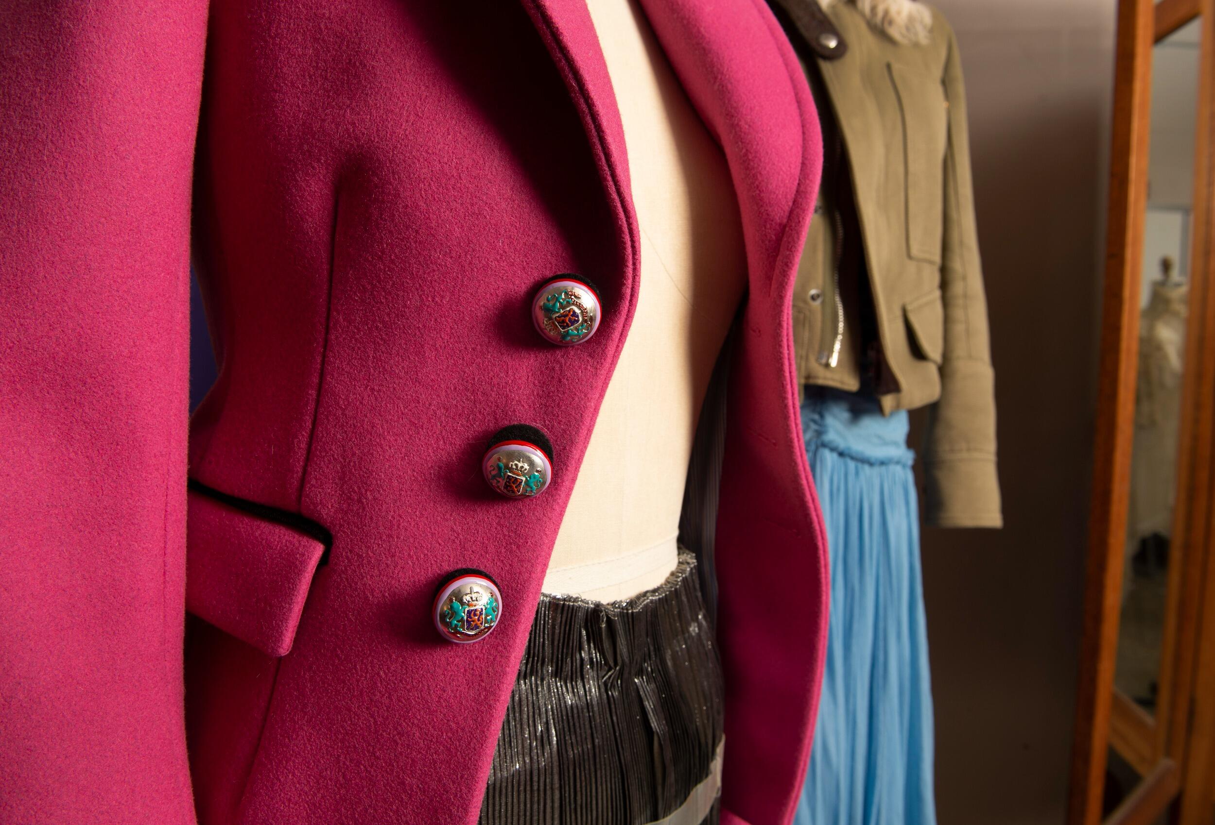 A photo of two maniquins wearing outfits that have jackets. 