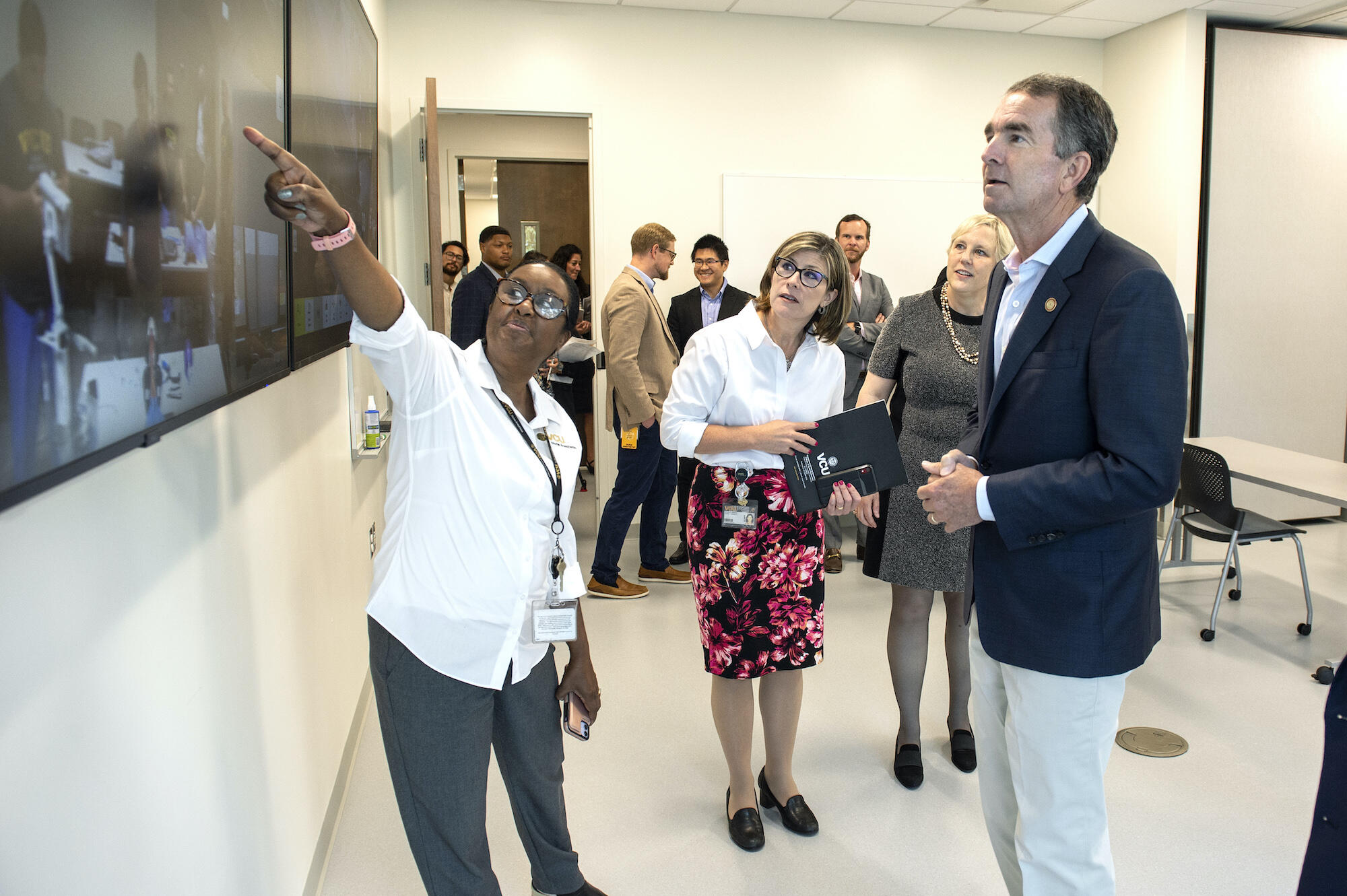 (From left) Beverly George-Gay, DNP, associate professor in the Department of Nurse Anesthesia, points to a screen showing the VCU College of Health Professions' two-way synchronous video conferencing capabilities as Nickie Damico, Ph.D., the department's chair, Susan Parish, Ph.D., dean of the college and Virginia Gov. Ralph Northam, M.D., look on.