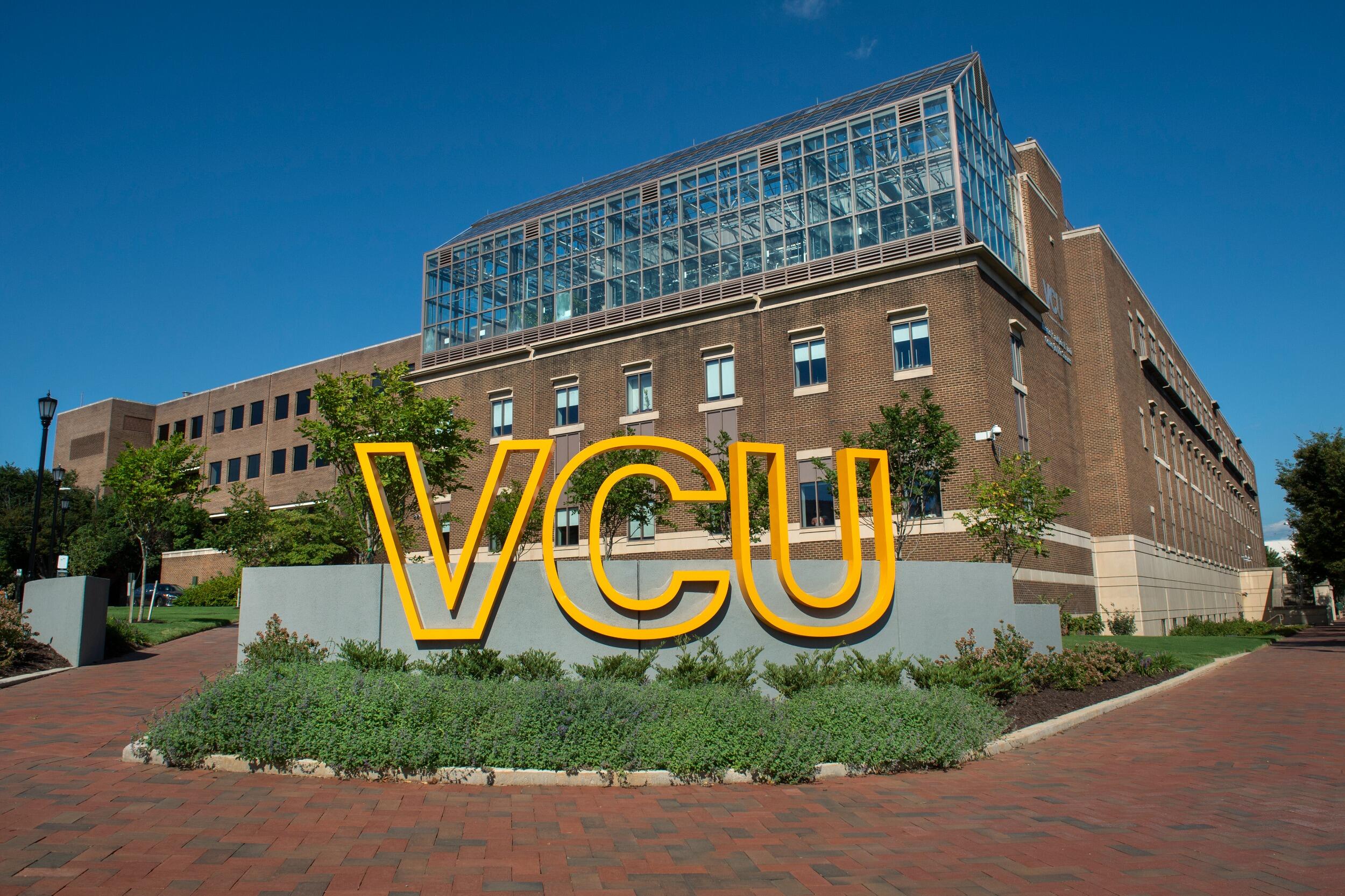 A large, sculptural sign that spells VCU in front of the Trani Building.