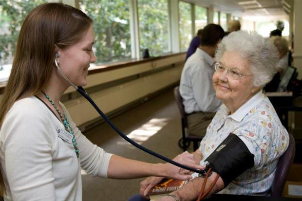 A pharmacy student works with a woman at Imperial Plaza, a senior living facility in Richmond.