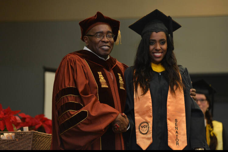 A woman and a man in caps and gowns for graduation.