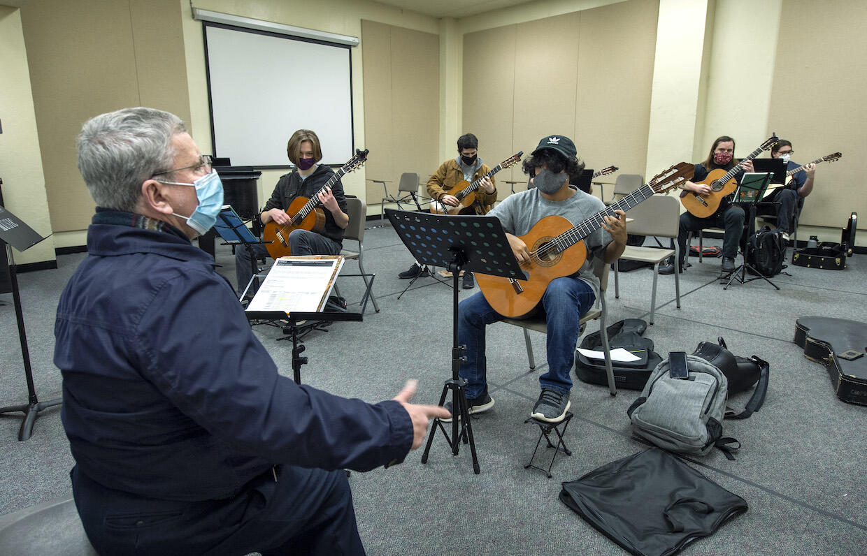 A professor leads a group of guitarists.