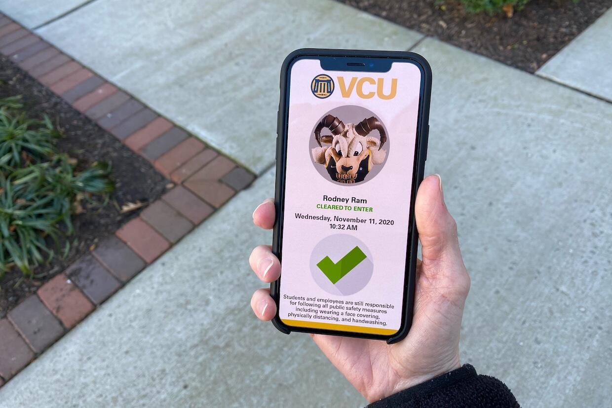 A person holding a cell phone displaying the V C U Entry Pass application with the cleared to enter screen for Rodney the Ram.