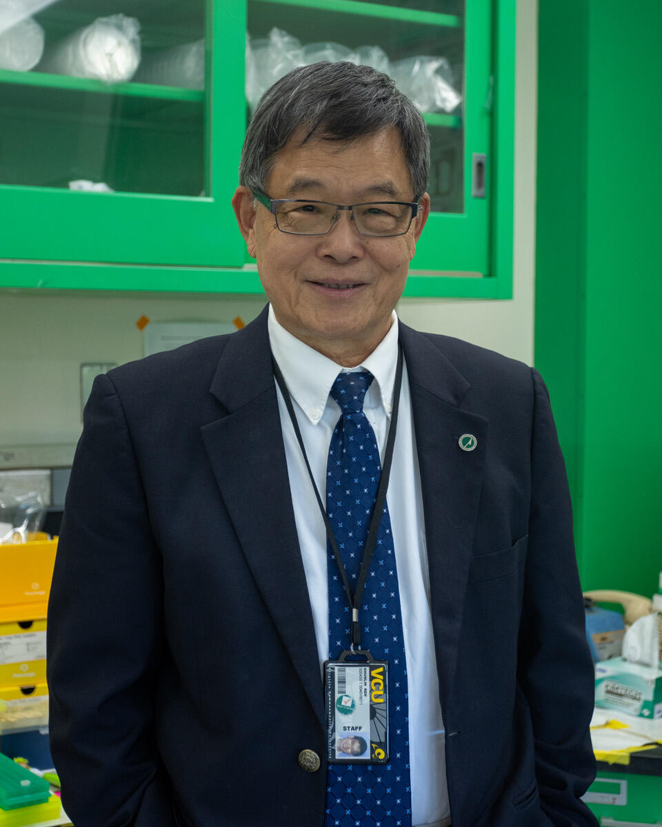 A photo of a man from the waist up. He is wearing a suit and tie. 