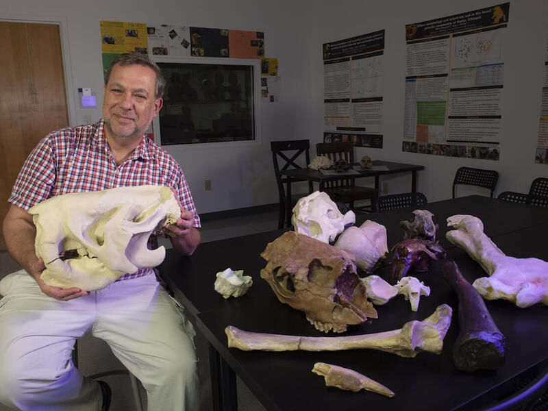 Bernard Means with a 3D-printed ground sloth skull at the Virtual Curation Laboratory.