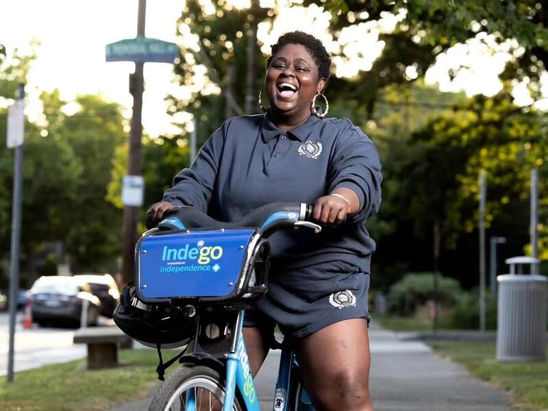 A photo of a woman standing over a blue bike. 