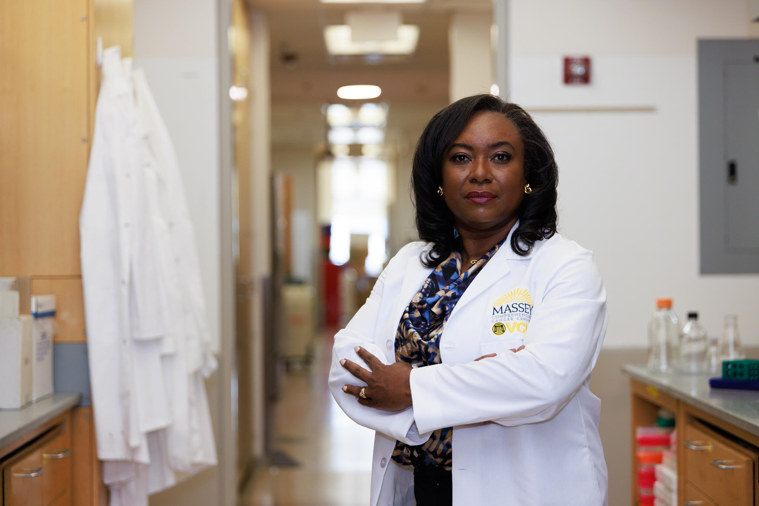 A woman in a lab coat with her arms crossed.