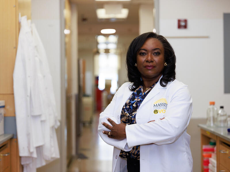 A woman in a lab coat with her arms crossed.