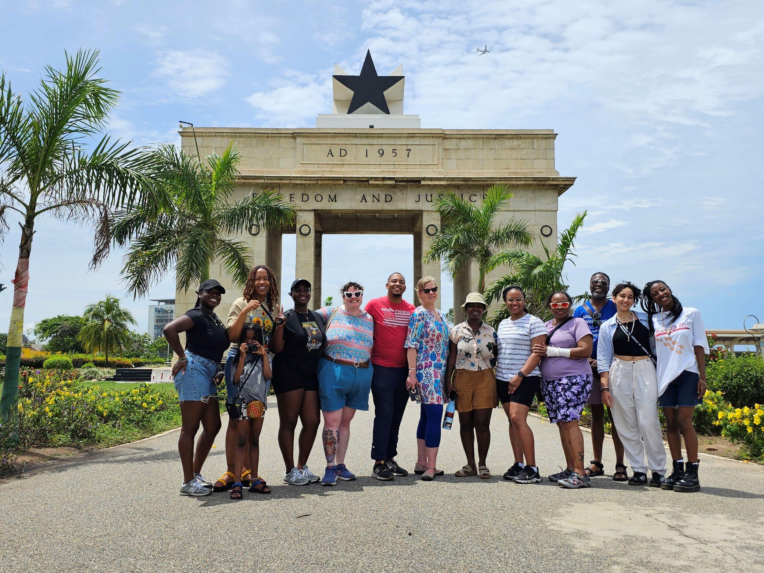 A large group of students pose in front of the Black Star Gate monument in Accra, Ghana.