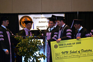 Senior D.D.S. students present check representing a gift of $125,000 to Dean Ron Hunt at graduation. From left: Mike Catoggio, Dean Hunt, David Turok, Harlan Hendricks and Eric Ballou.