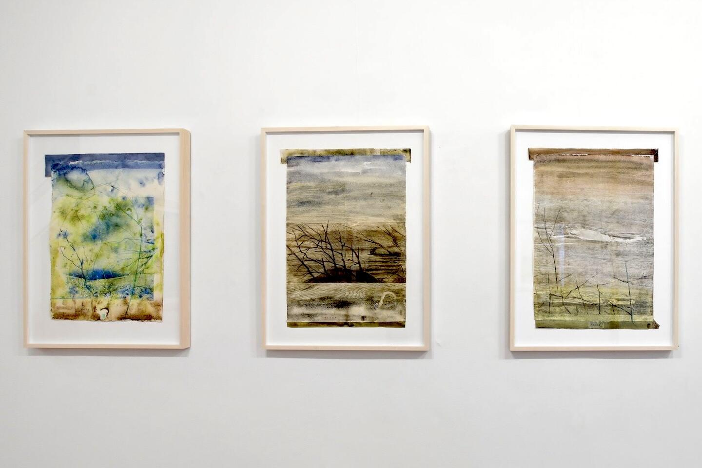 A photo of three landscape paintings. 
