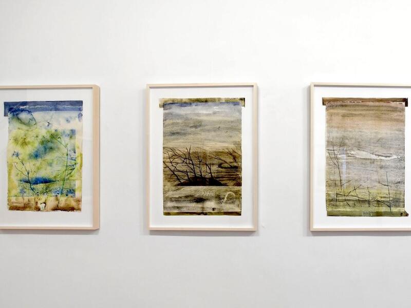 A photo of three landscape paintings. 