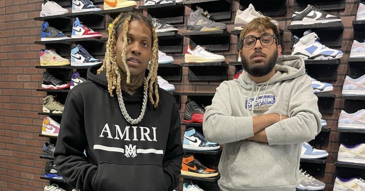 Two men standing next to each other in front of a display of sneakers. 