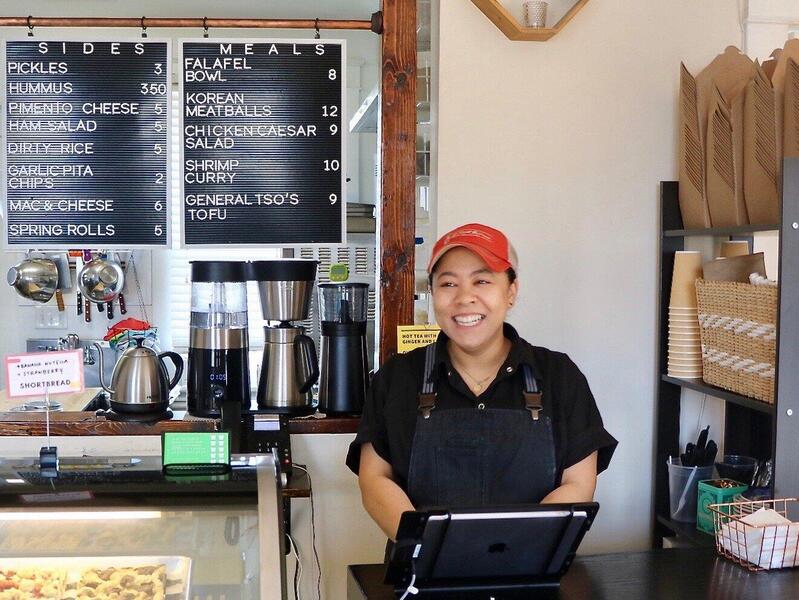 A person behind the counter of a restaurant.
