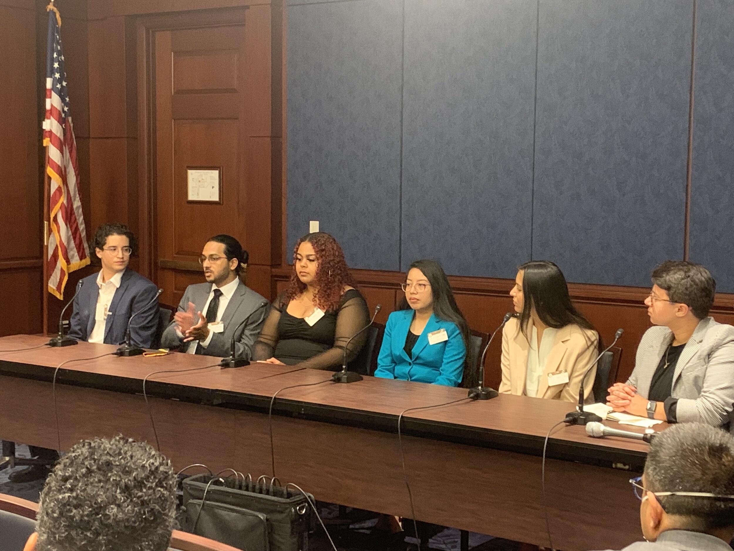 A panel of six students sharing their stories at a congressional briefing 