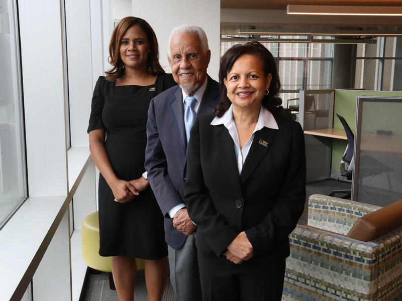 Two women standing next to a man