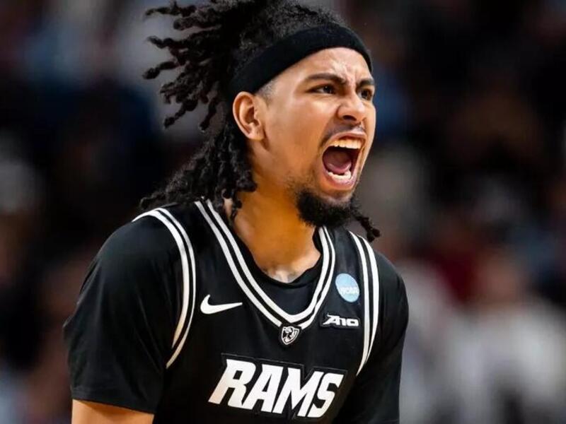 A basketball player in a black Rams jersey shouts in celebration.