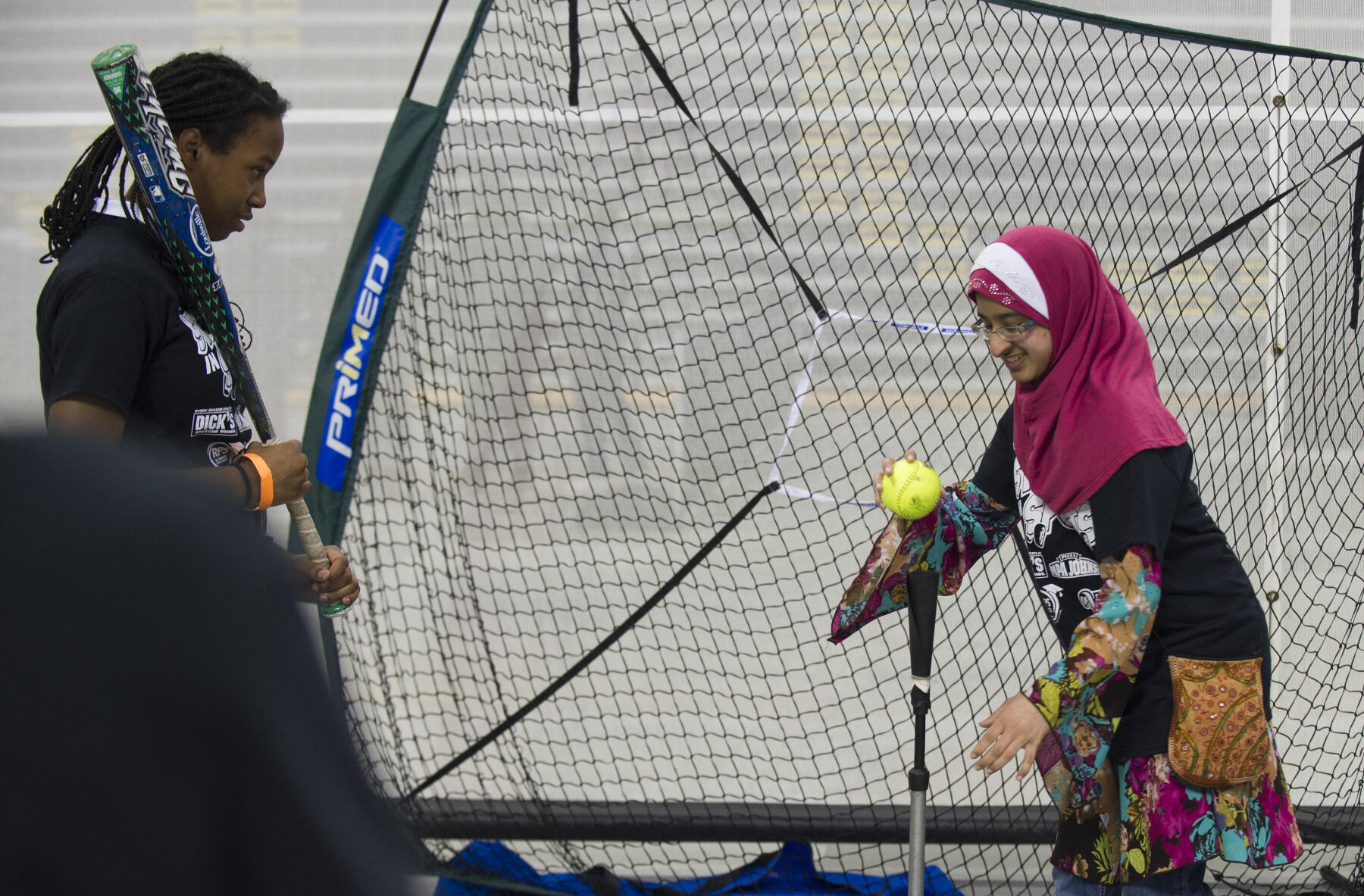 Farwa Hussain, a sophomore majoring in math education in the School of Education, helps Richmond Public Schools students as they try out "Swing Tracker" technology that measures how fast they swing the bat.
