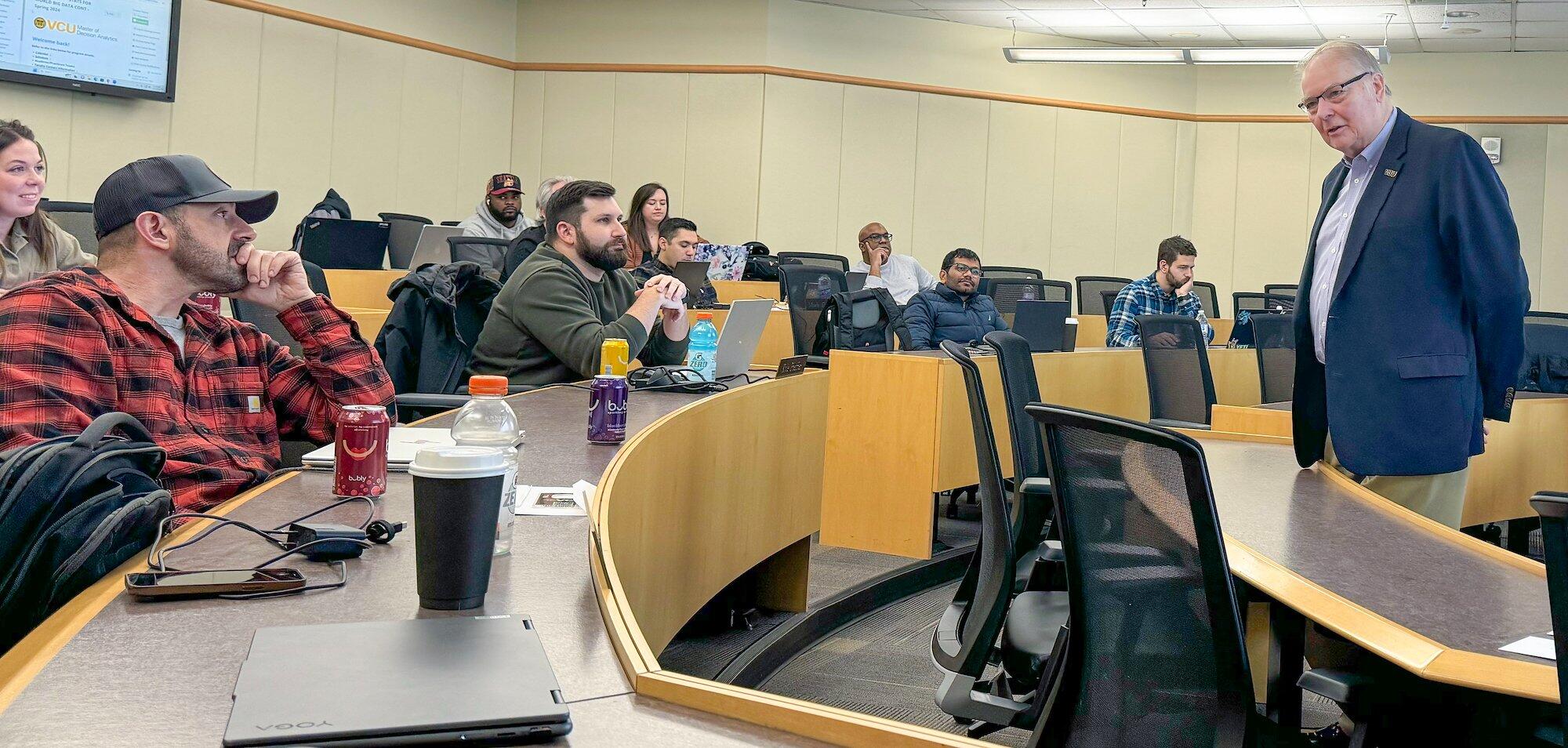 Stephen Custer, standing in a classroom and greeting VCU’s spring 2024 Master of Decision Analytics Weekend Program students as the semester began. (VCU School of Business)