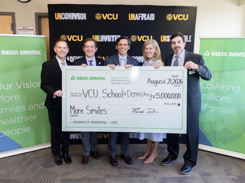 Four men and a woman stand behind a large check for $5 million made out to the VCU School of Dentistry.